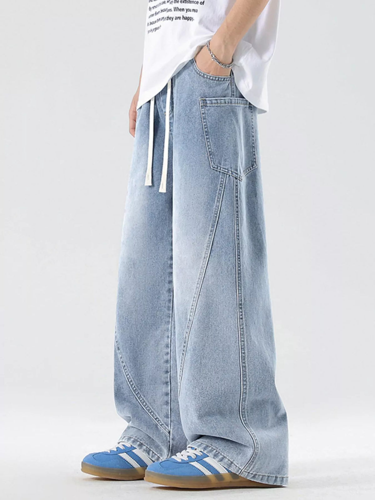 Men's vintage wide-leg jeans in light blue denim with front pocket seams and drawstring.