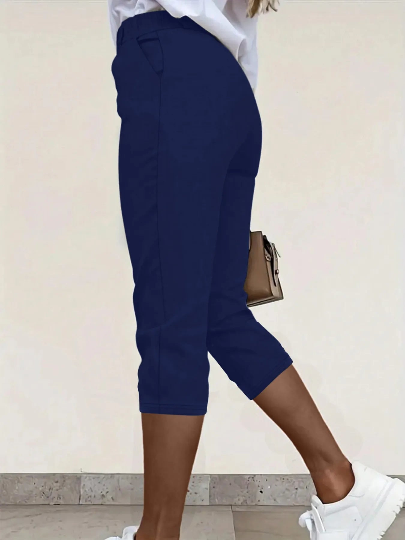 Navy pleated cropped pants with side pockets, button closure
