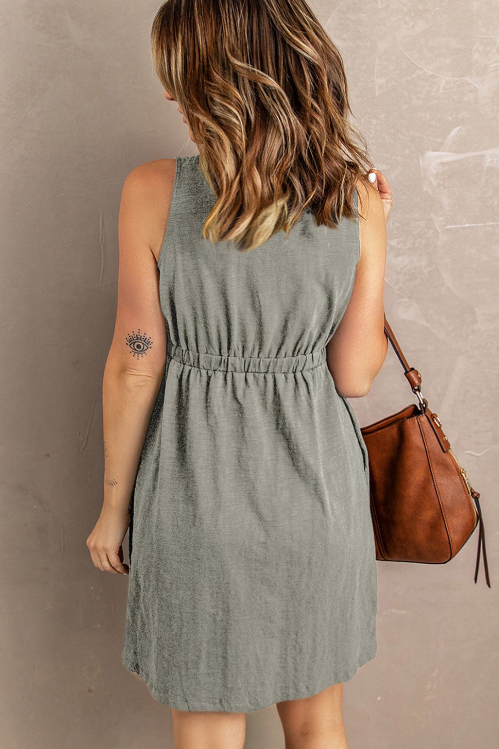 Gray sleeveless button-front mini dress with back yoke and gathered waist detail