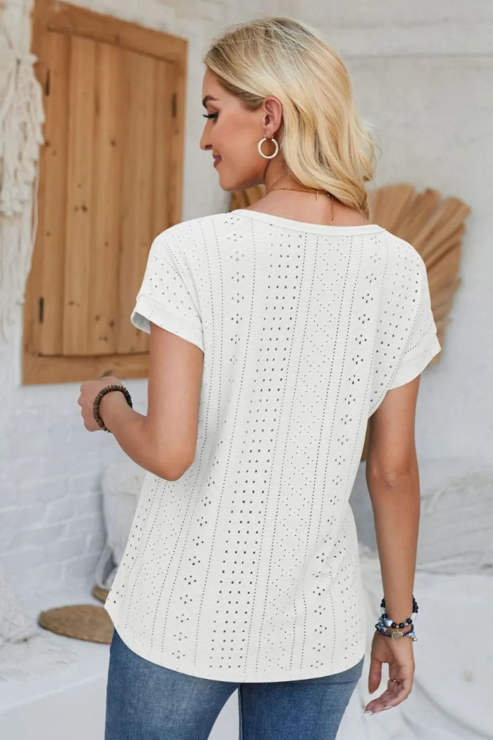 Eyelet round-neck rolled short-sleeve T-shirt in white, rear view with vertical cutouts