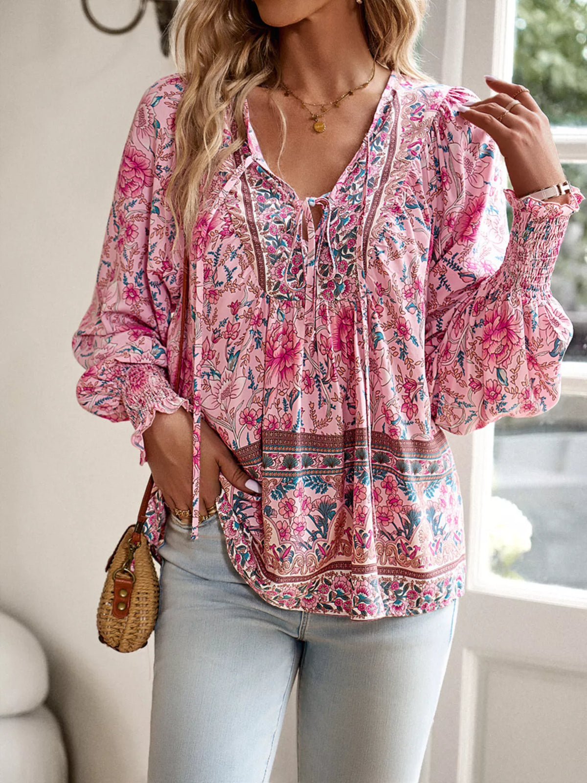Pink floral tie-neck blouse with textured smocked front and elastic cuffed sleeves