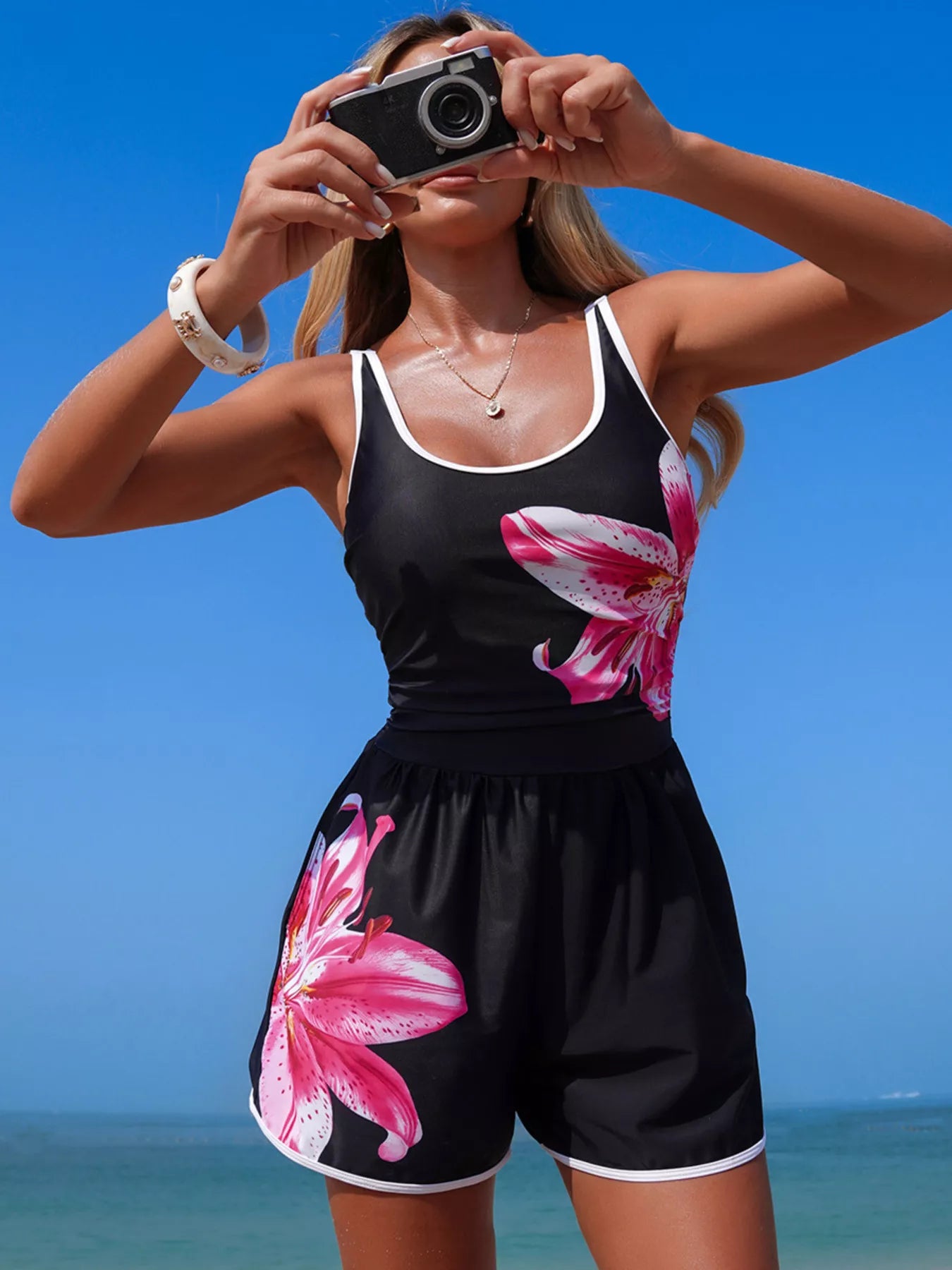 Contrast-trim scoop-neck one-piece swimsuit in black with pink lily print.
