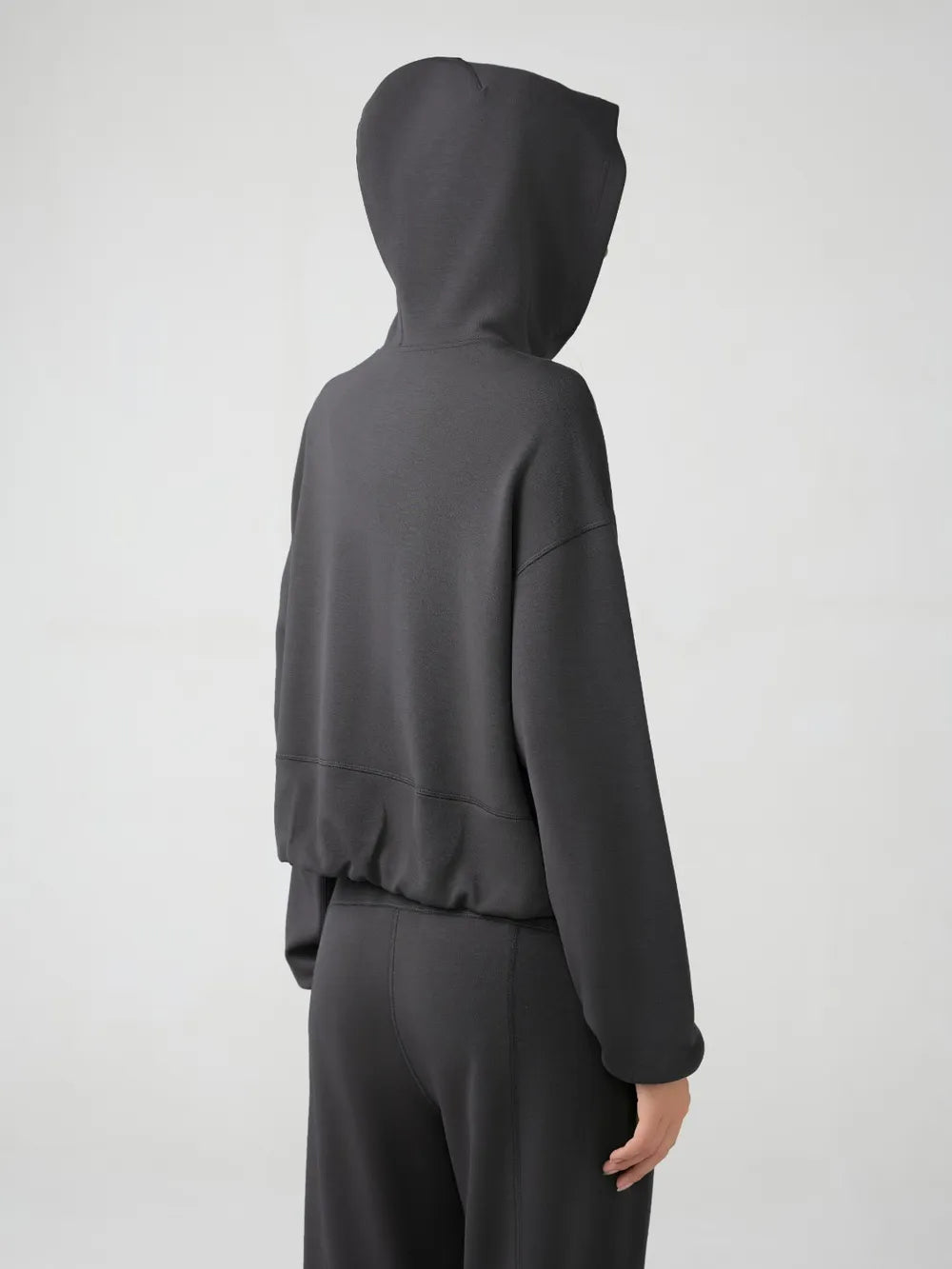 Dark gray hooded active zip jacket, back view with dropped shoulder silhouette