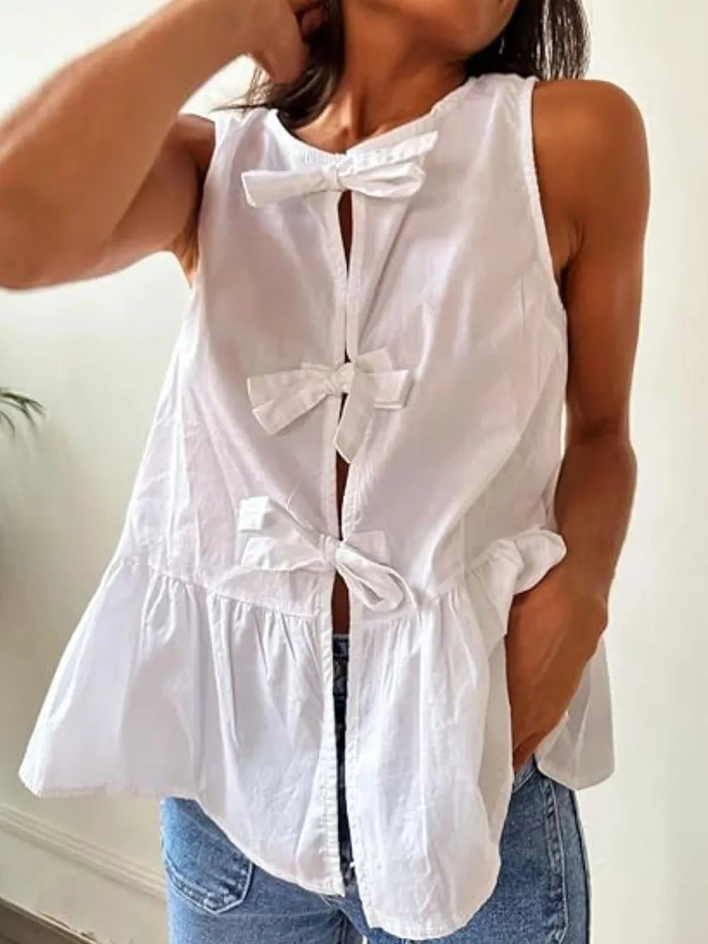 White sleeveless tank top with bow-tie front and tiered peplum hem