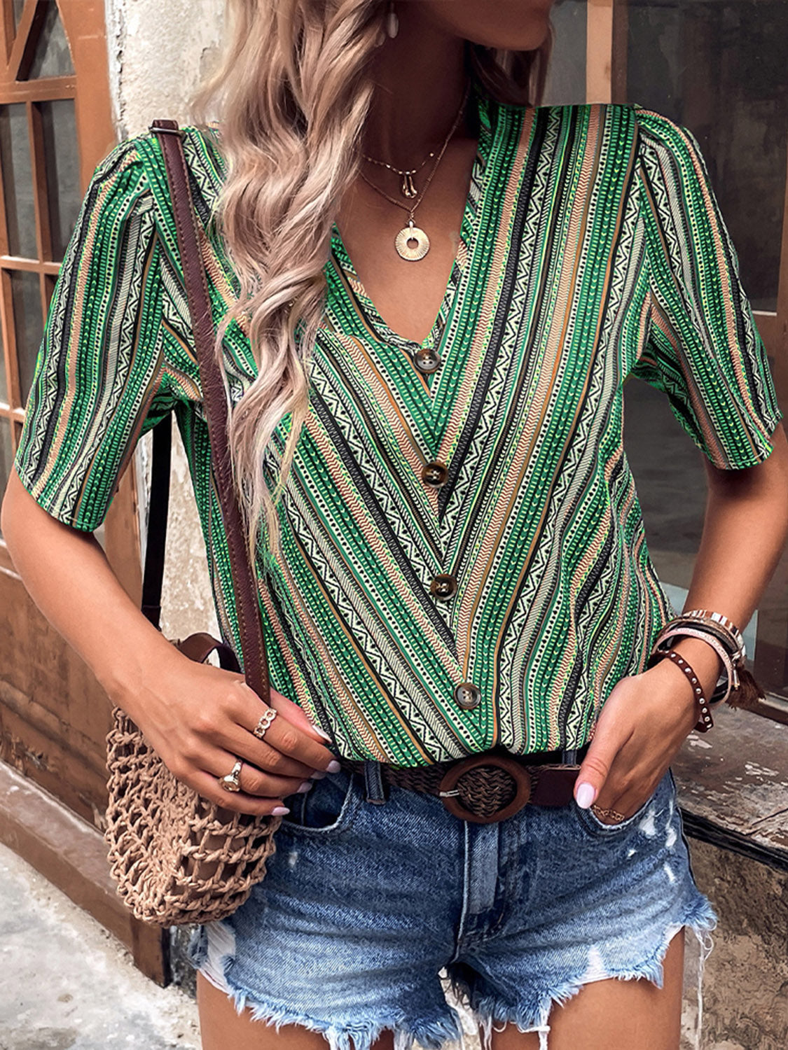 Shiny printed v-neck button-up short sleeve top, front view, green and white striped pattern