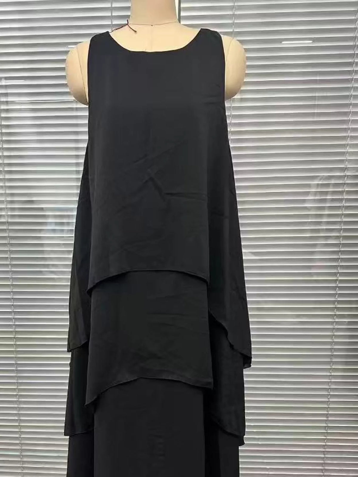 Black sleeveless maxi dress with layered ruffle tiers on a mannequin