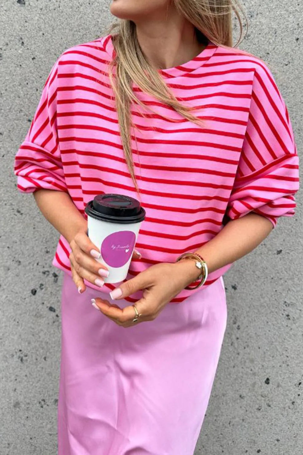 Hot pink striped round-neck long-sleeve sweatshirt, loose silhouette and wide sleeves.