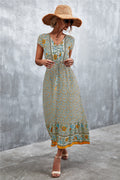 V-neck printed maxi dress with short sleeves, beige base, teal and orange floral border.