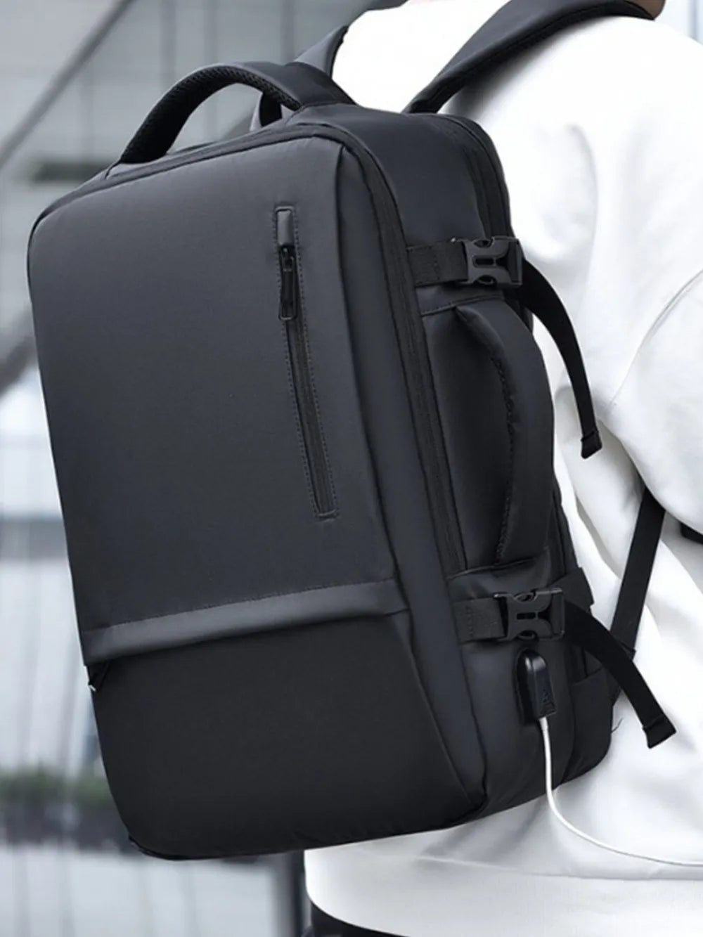Dark gray backpack with top handle, adjustable straps, and front zip pocket