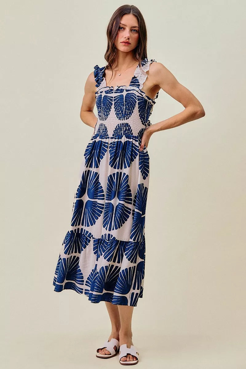 Front view of navy and white abstract print smocked bodice tiered midi dress