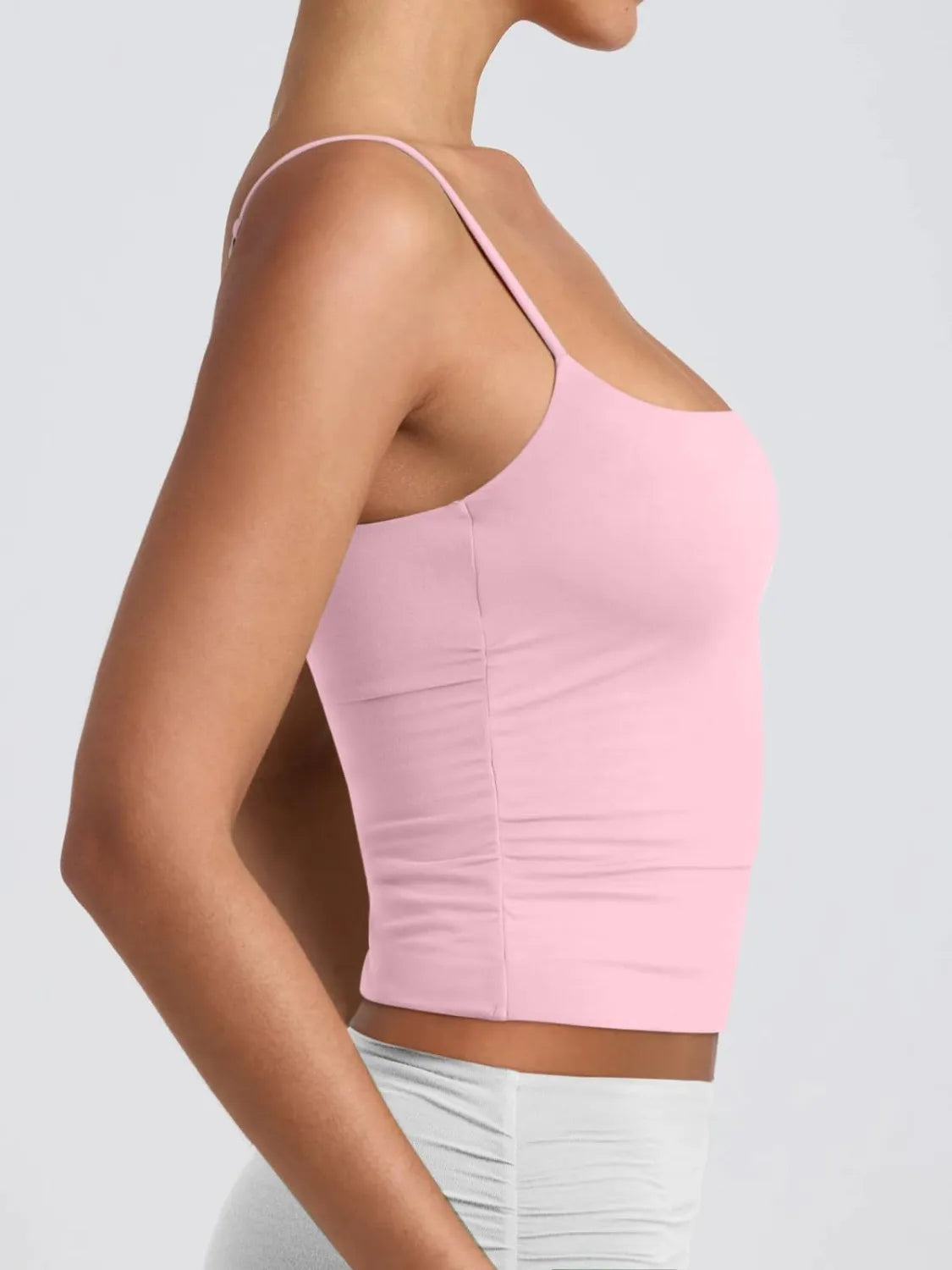 Scoop neck cami in blush pink from the side, thin straps and smooth fitted shape.