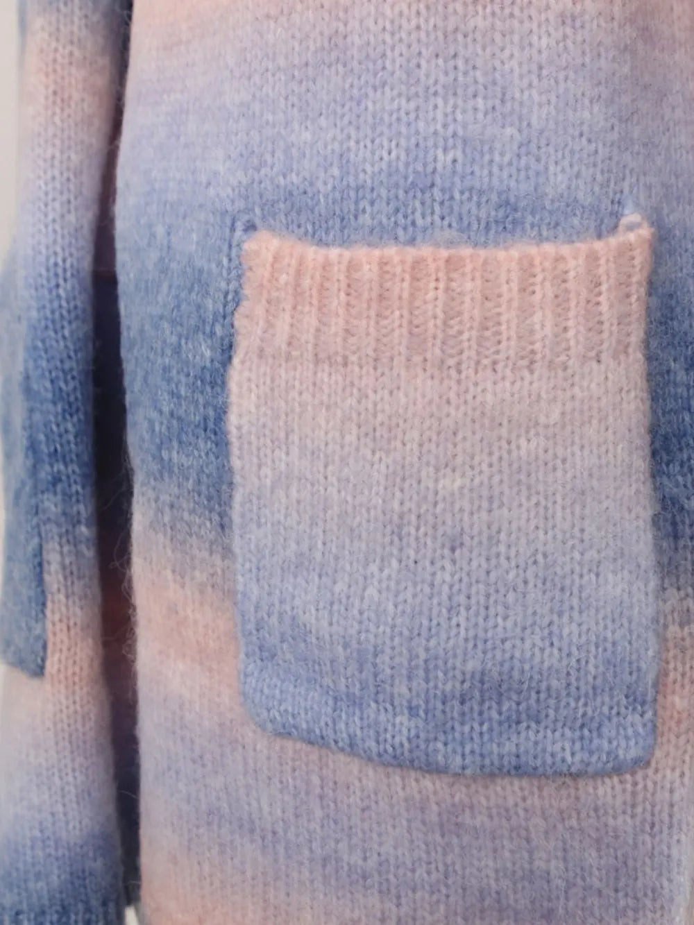 Front pocket detail on a blue-toned gradient open cardigan