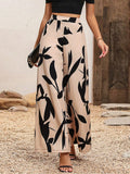 Printed wide-leg pants in tan with black leaf pattern, elastic waist, ankle length.