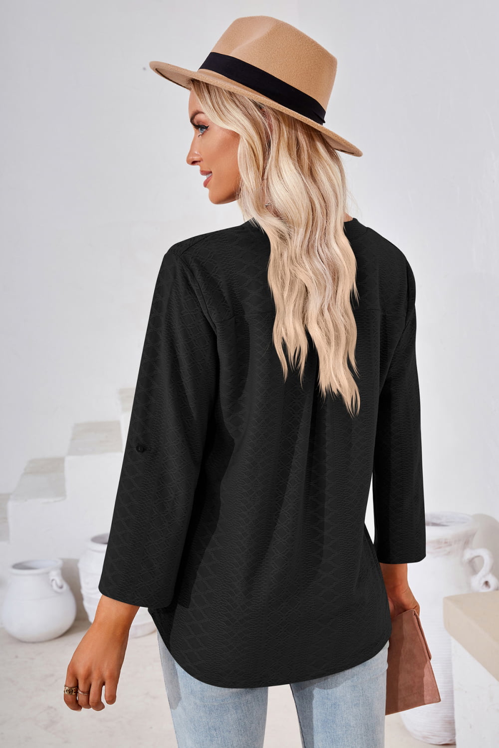 Black V-neck blouse with rolled cuffs and textured front