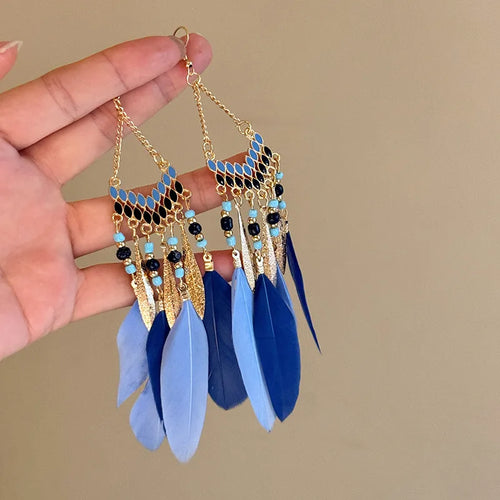 Gold-tone chandelier earrings with blue beaded accents and long blue feather tassels