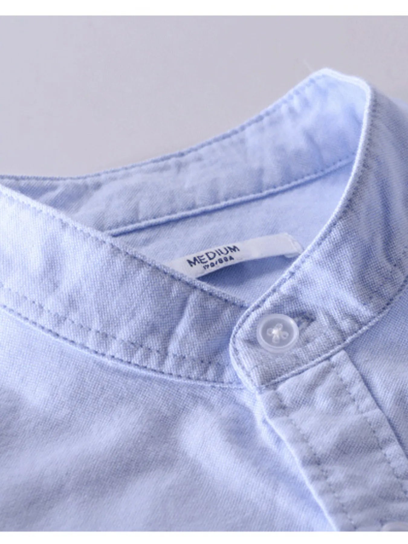 Long-sleeve button-up shirt in light lavender, close-up of collar and button placket