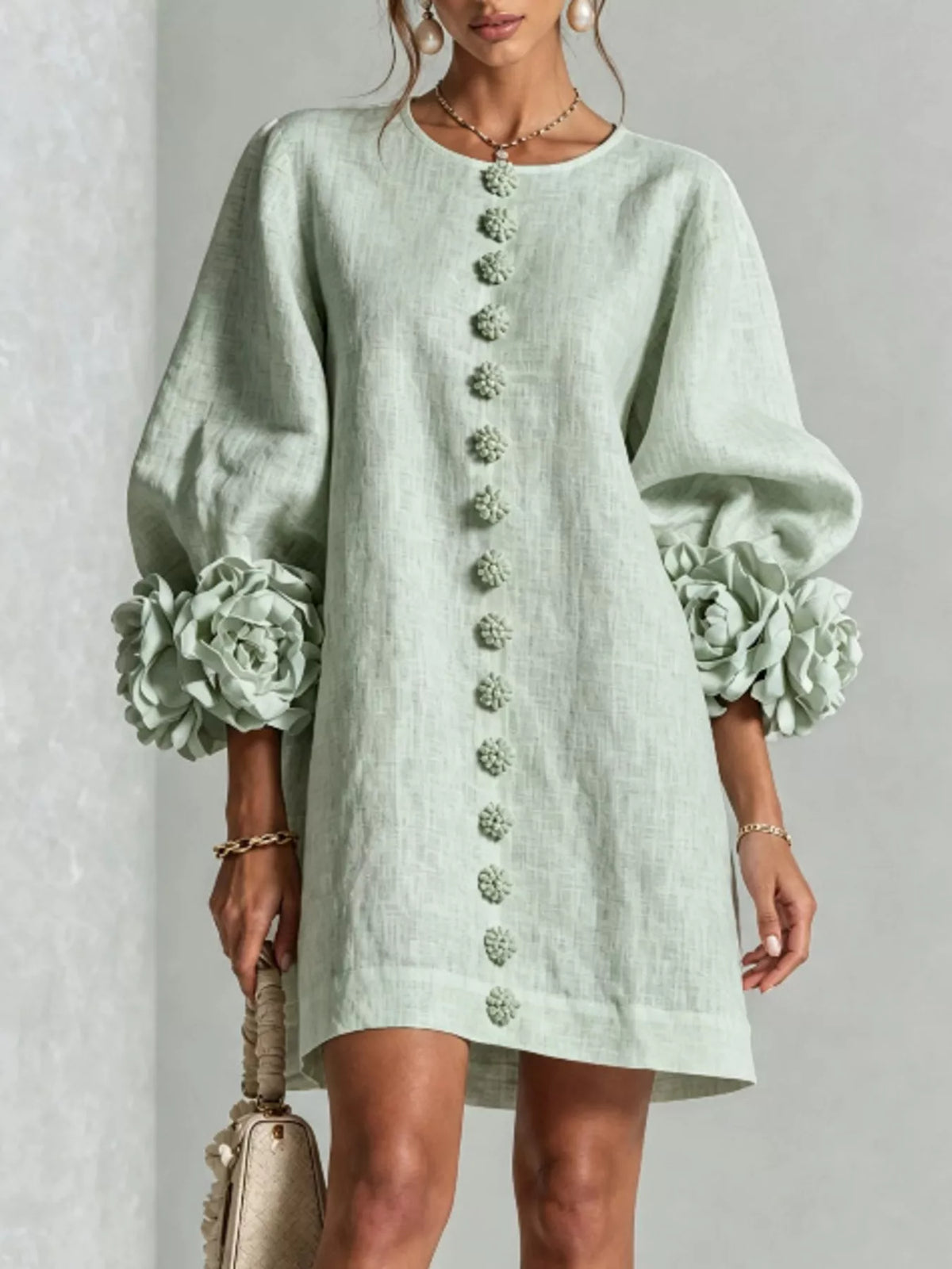 Sage green linen mini dress with round neck and vertical 3D floral button trim
