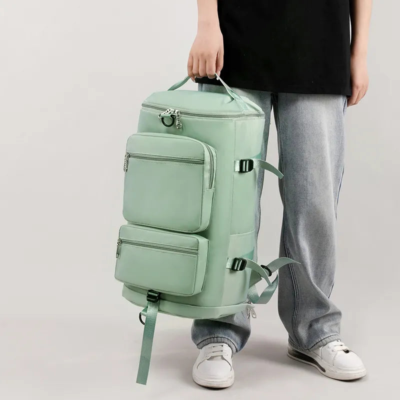 Large mint green travel backpack with front zip pockets and side straps, top handle.