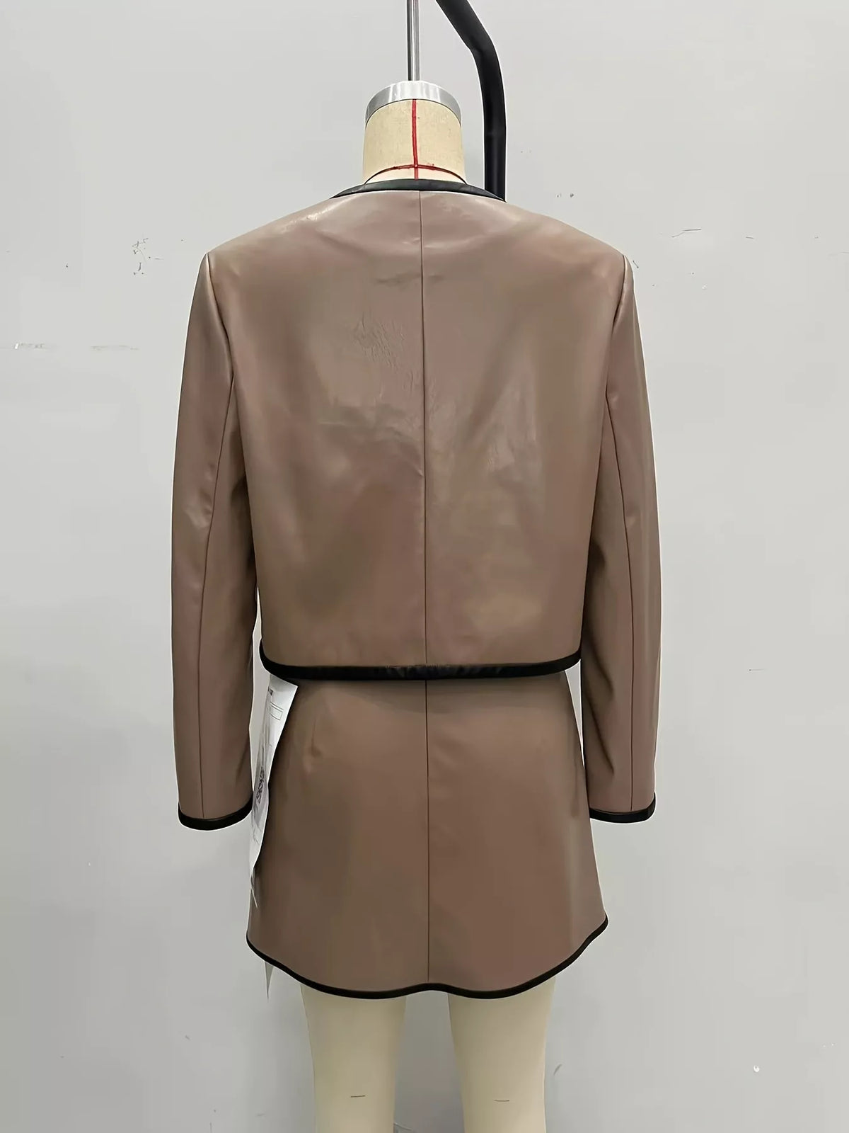 Tan jacket and skirt set back view with black contrast hem and waistband trim