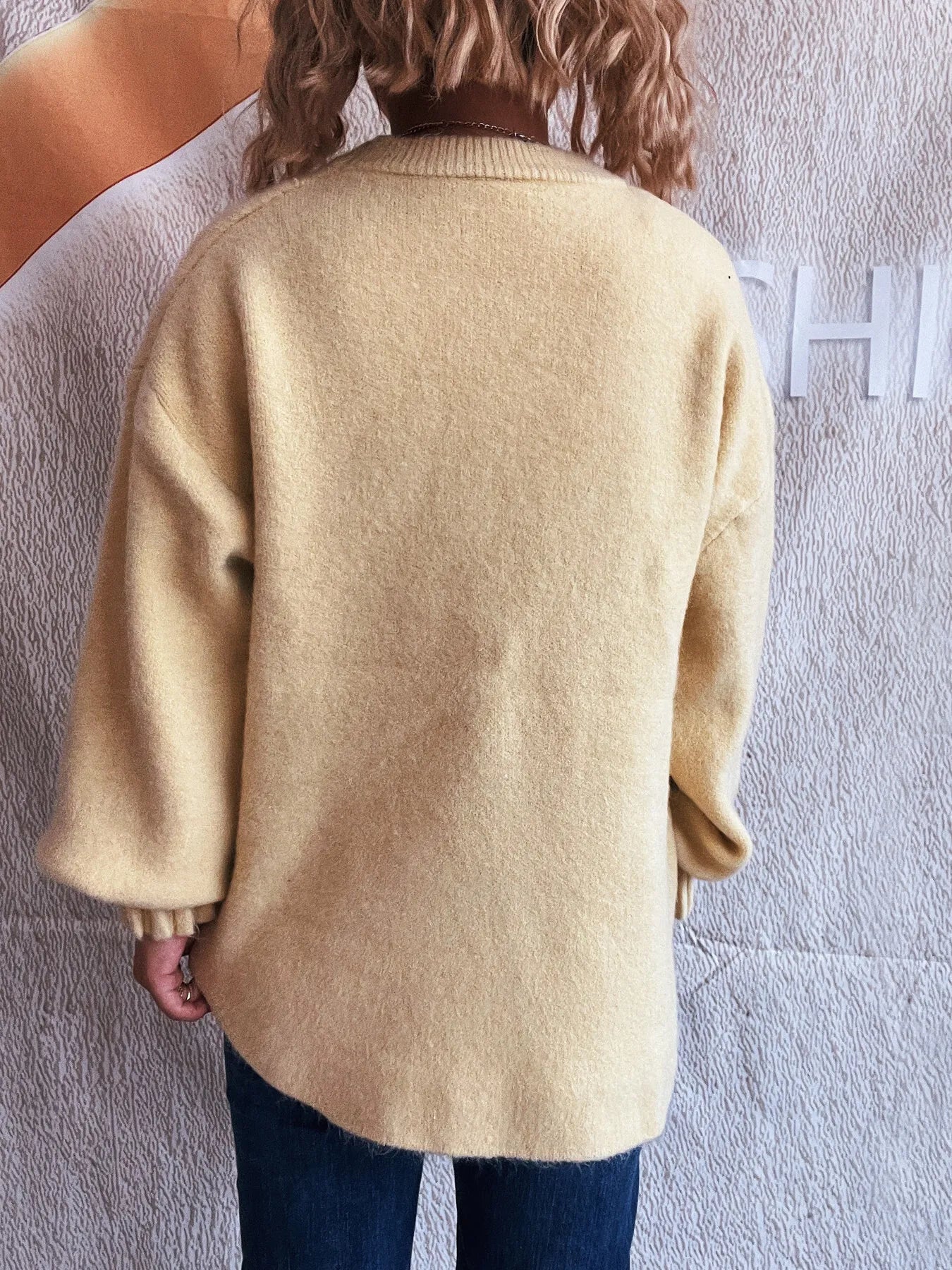 Cream round neck dropped-shoulder sweater, back view with ribbed cuffs