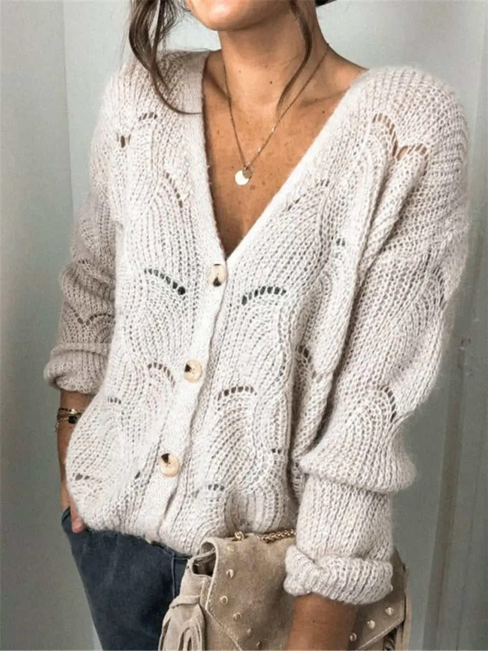 Beige openwork button-up cardigan with V-neck and long sleeves, knit eyelet pattern.
