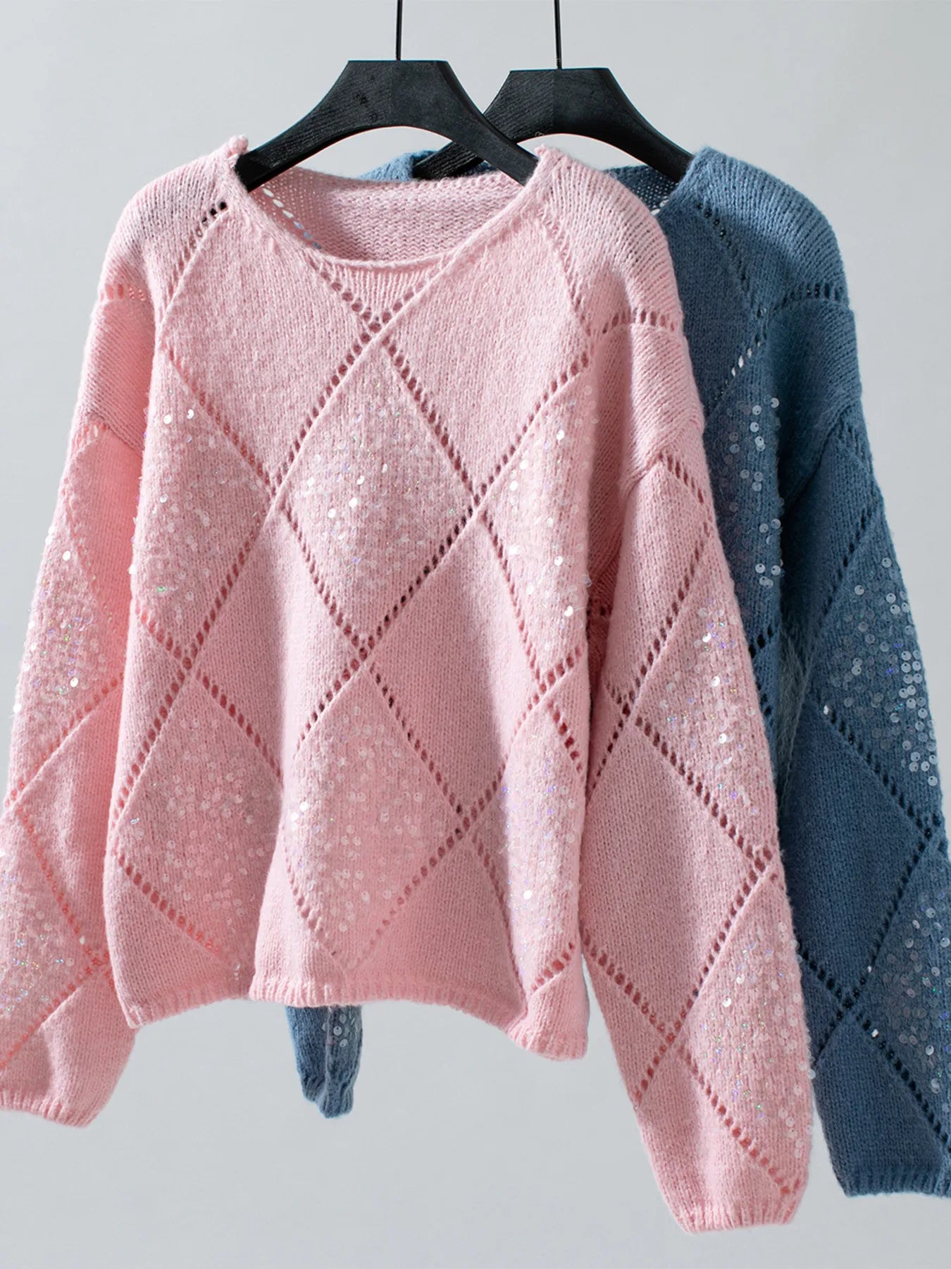 Pink and blue sequin openwork long-sleeve sweaters on hangers