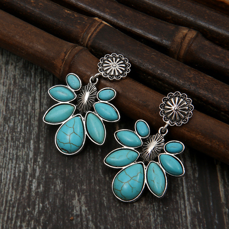Turquoise flower drop earrings with a large oval center petal and silver-tone accents.