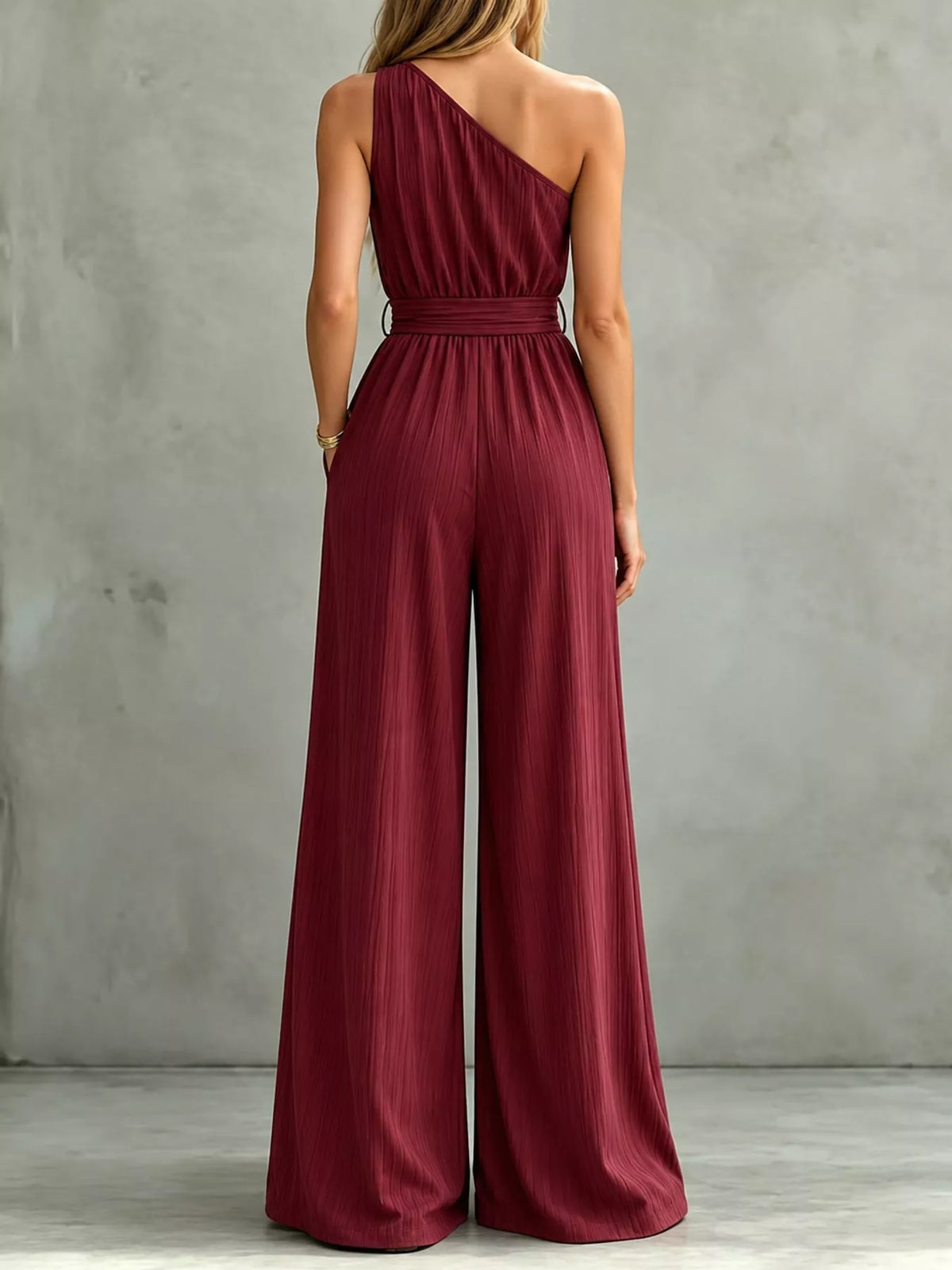 Burgundy one-shoulder wide-leg jumpsuit, back view with tied waist