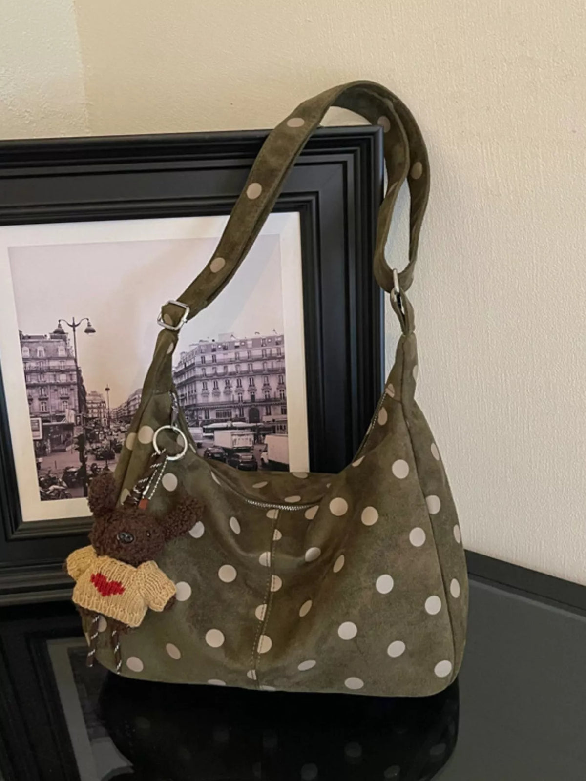 Green suede polka-dot shoulder bag with adjustable strap and front pocket