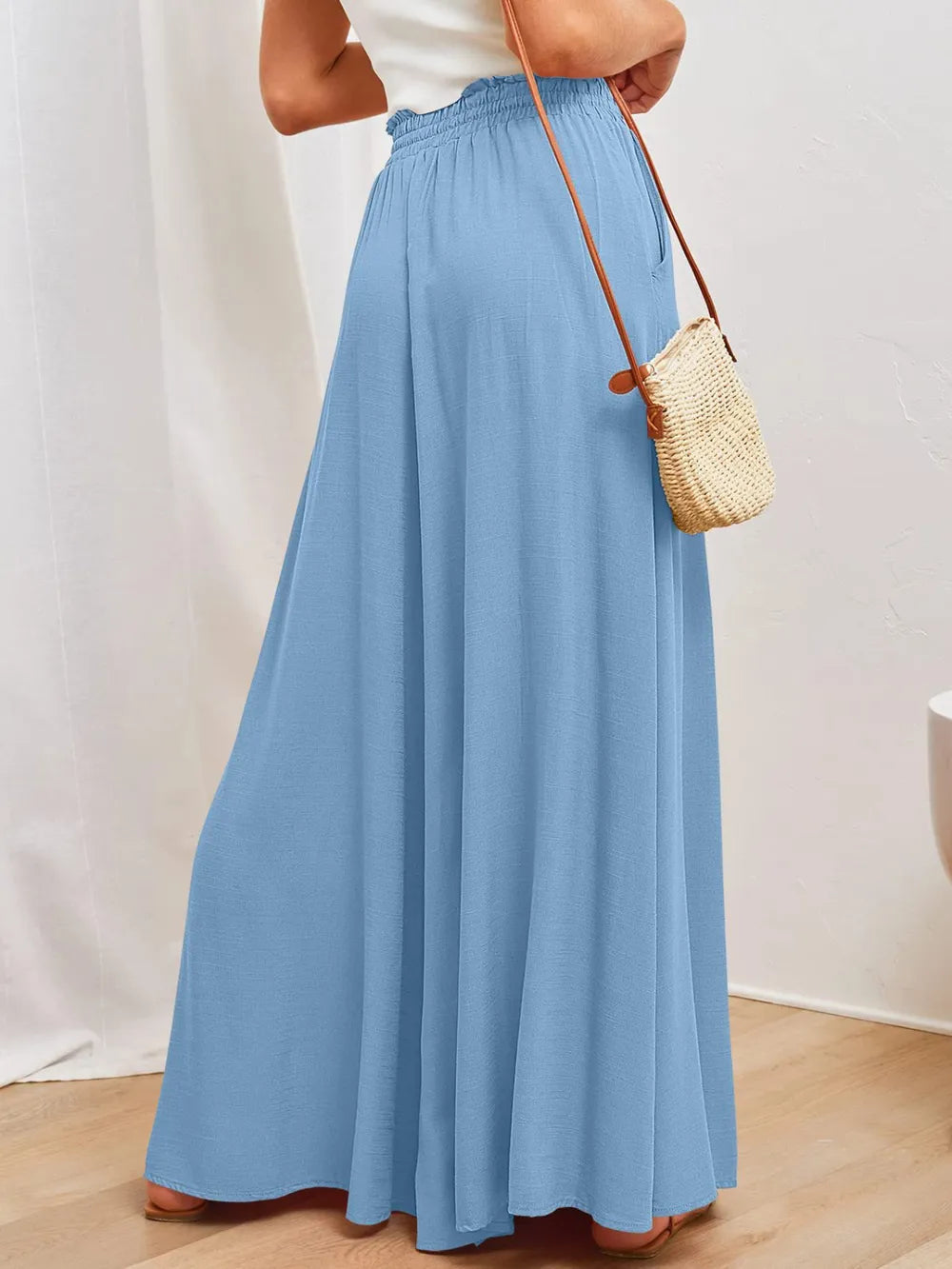 Light blue wide-leg pants with drawstring elastic waist and side pockets, angled view