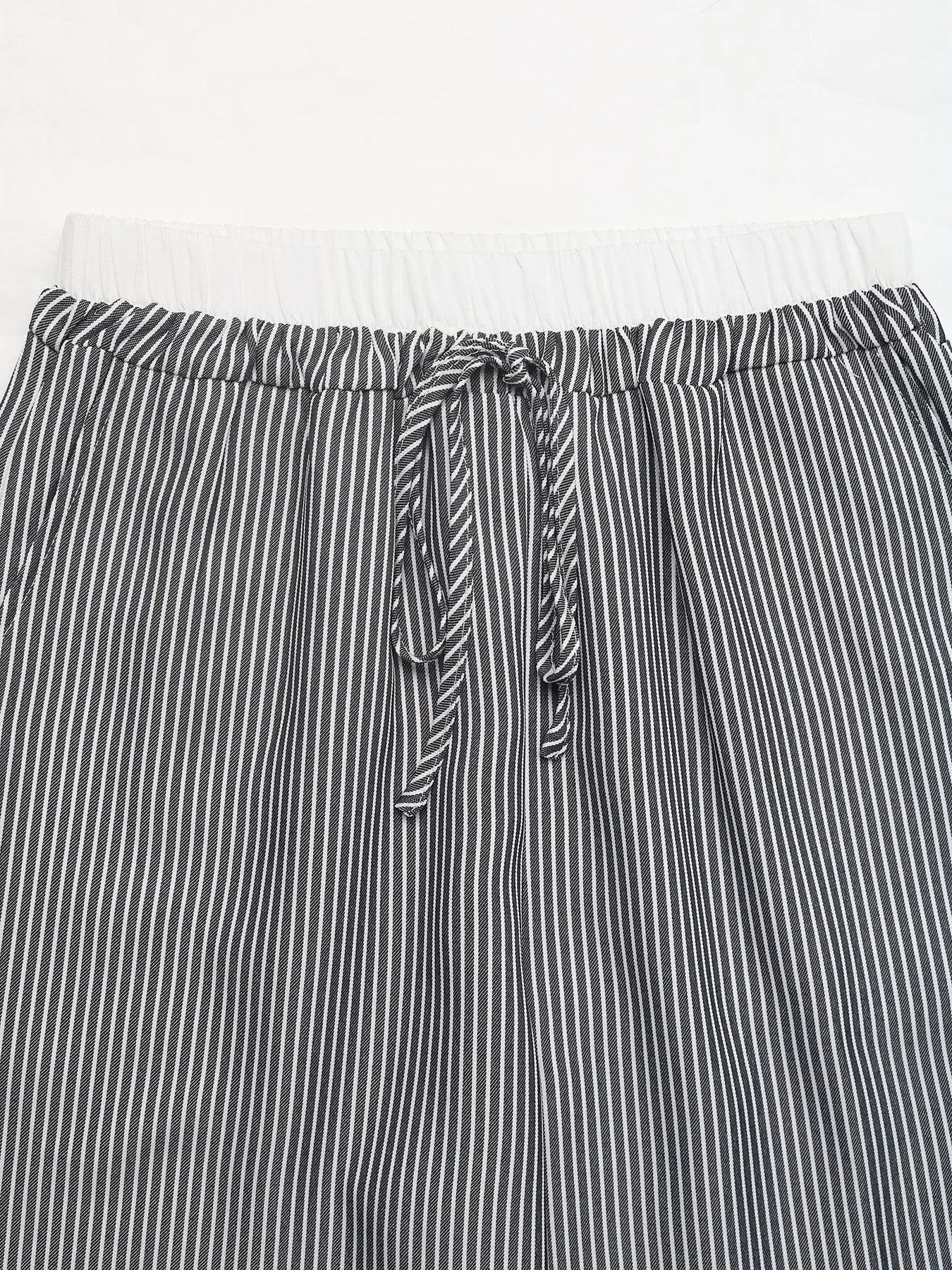 Elastic waistband and drawstring knot on striped wide-leg pants, black and white stripes