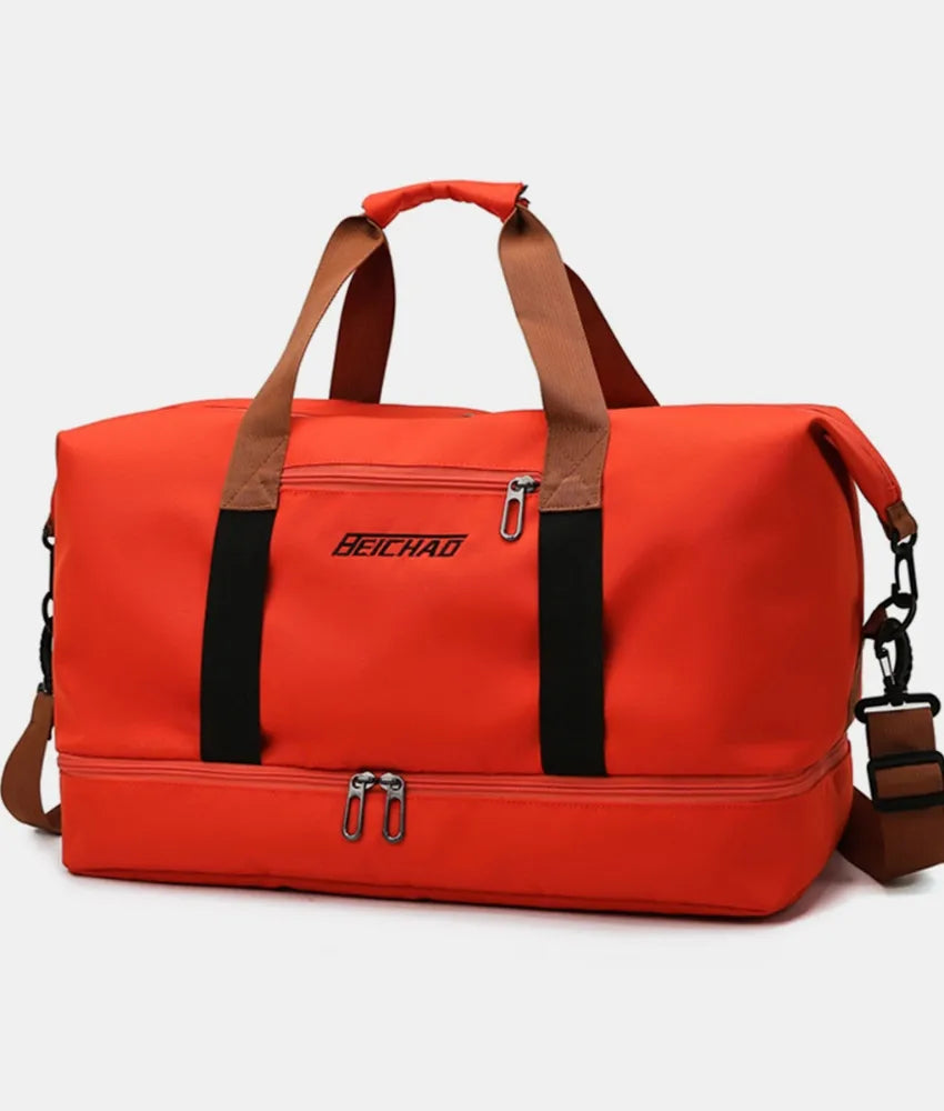 Orange oversize travel duffle bag with tan handles and front zipper pocket