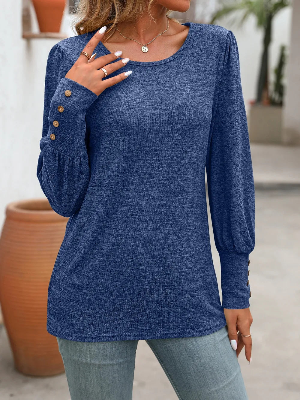 Navy long-sleeve t-shirt with round neck and button detailing on sleeves.