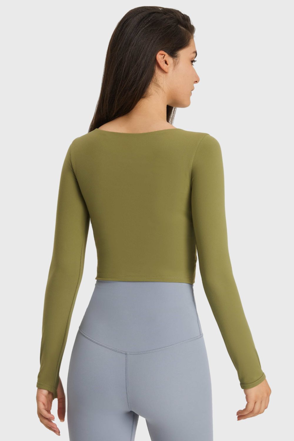 Olive green long-sleeve cropped sports top, back view with waist cutout