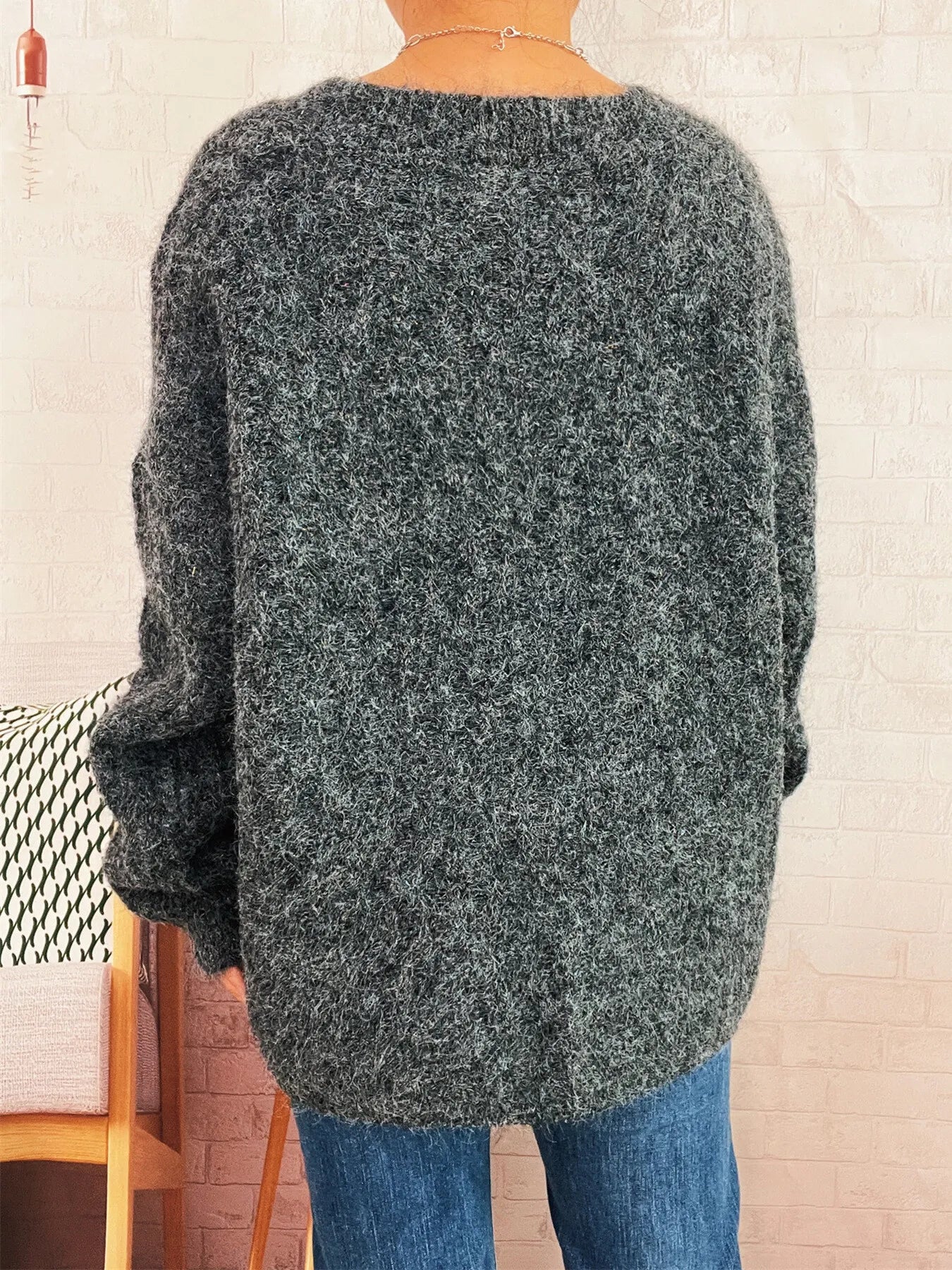 Dark gray knit cardigan back view with long sleeves and textured cable pattern