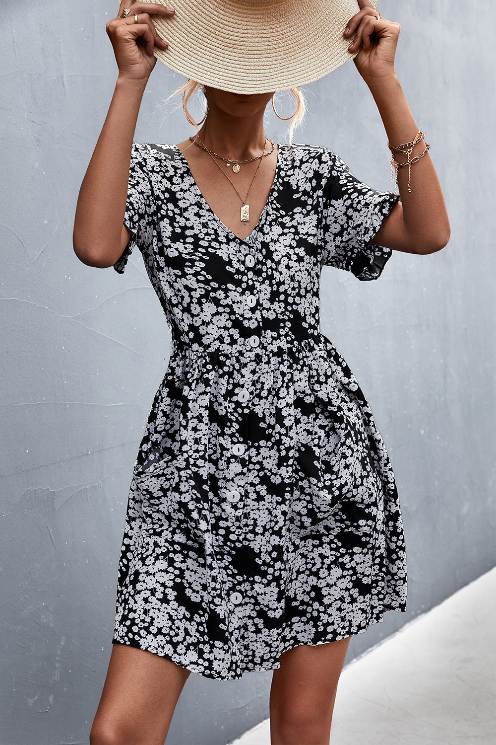 Black floral printed button-front dress with V-neck, short sleeves, and patch pockets.