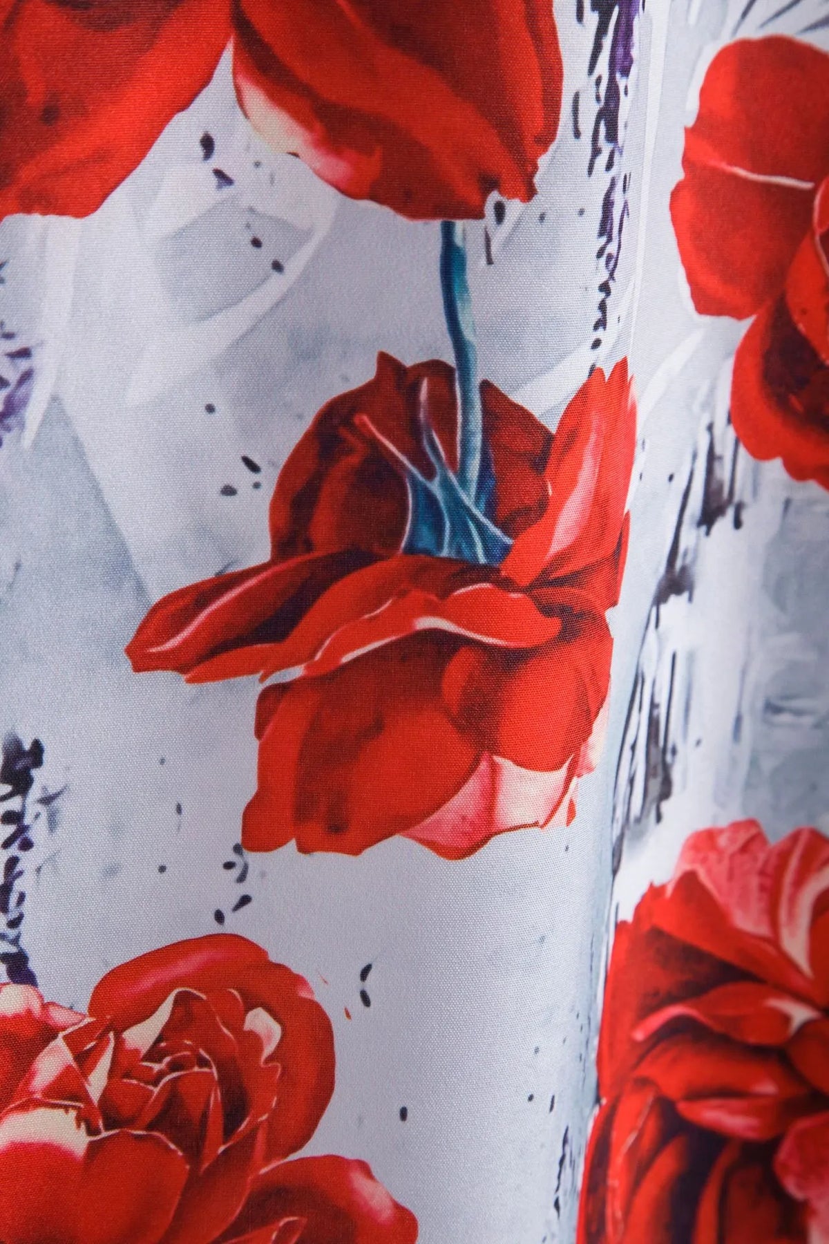 Floral button-up shirt detail, large red rose print with ink splatter on white