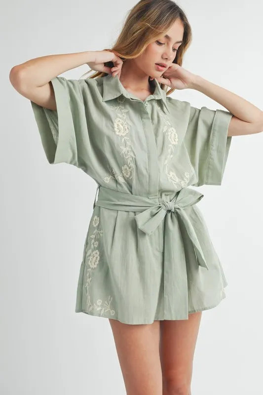 Dusty sage embroidered romper with short sleeves, collared neckline, and belt tie