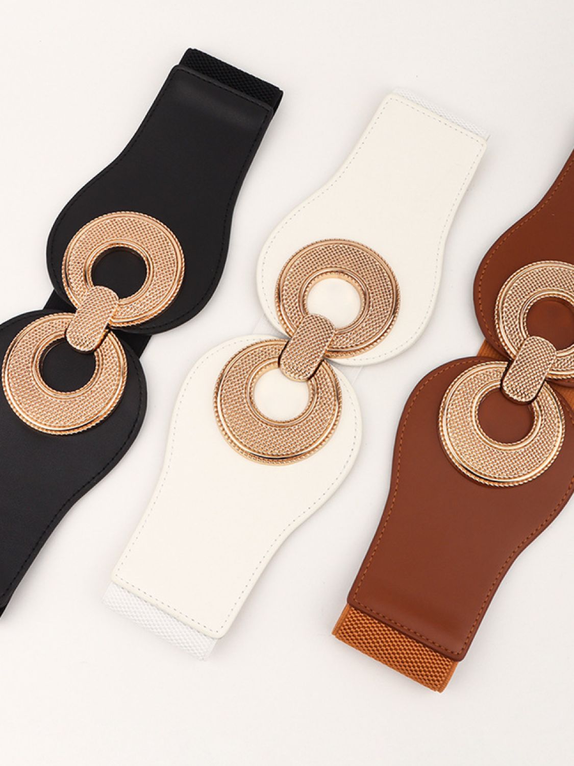 Elastic vegan belts in black, cream, and caramel with ring buckle hardware