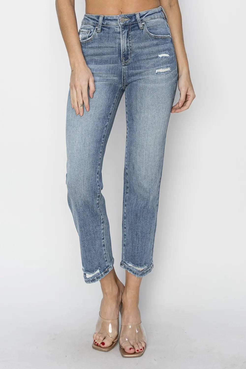 High-waist distressed cropped jeans in medium wash with frayed cuffs and rips.