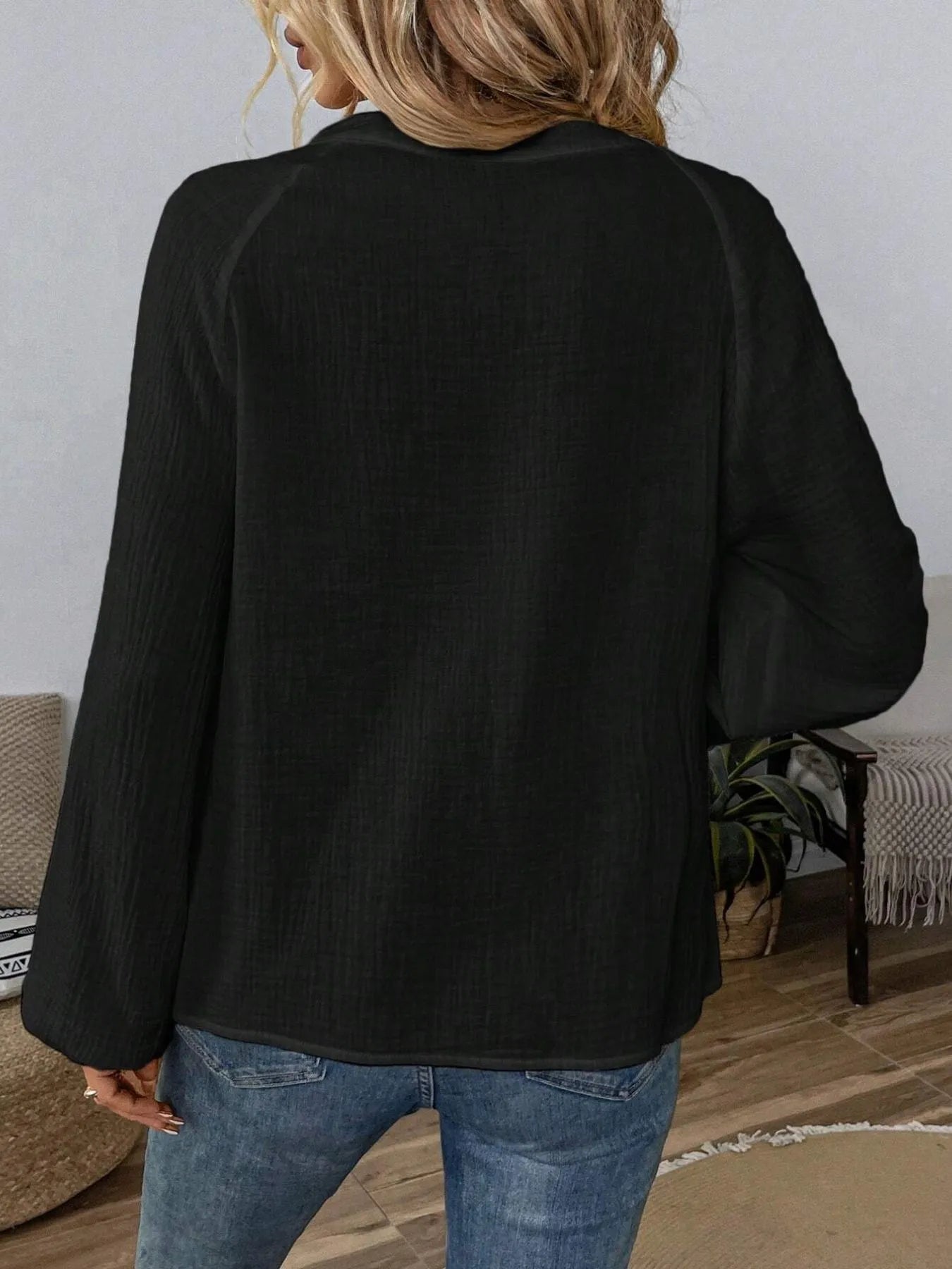 Black long sleeve blouse, back view, plain textured weave with relaxed shoulder