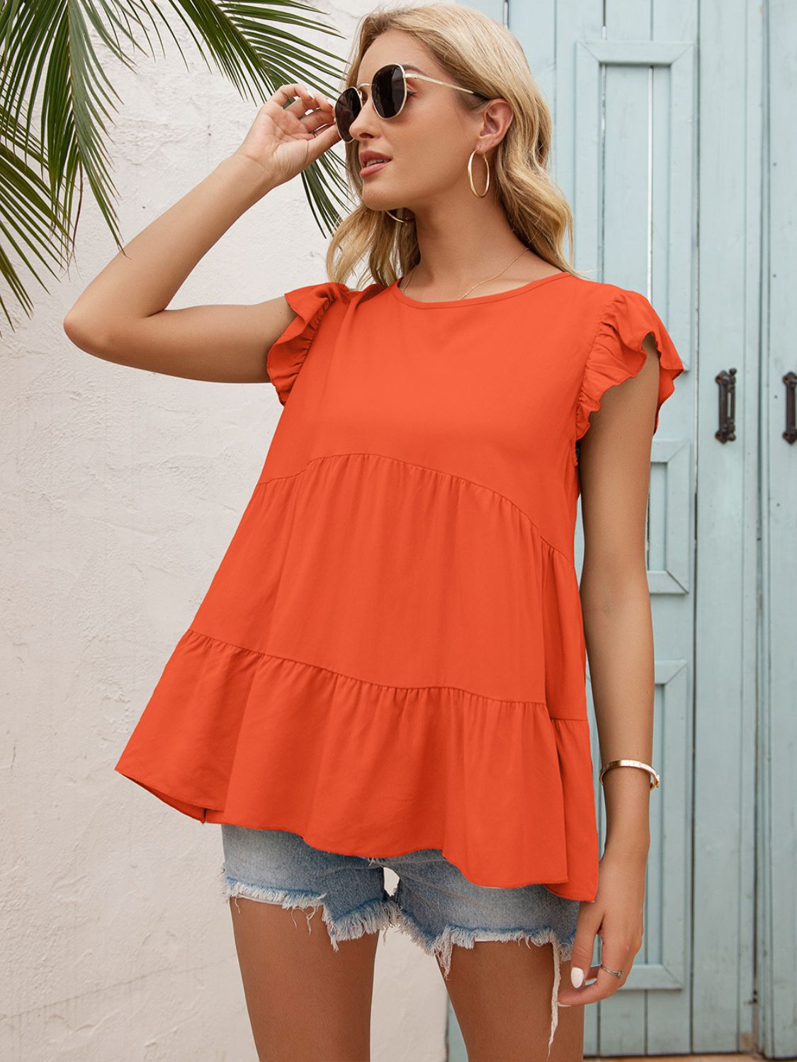 Orange round-neck tiered blouse with flutter sleeves and ruffled tiered hem