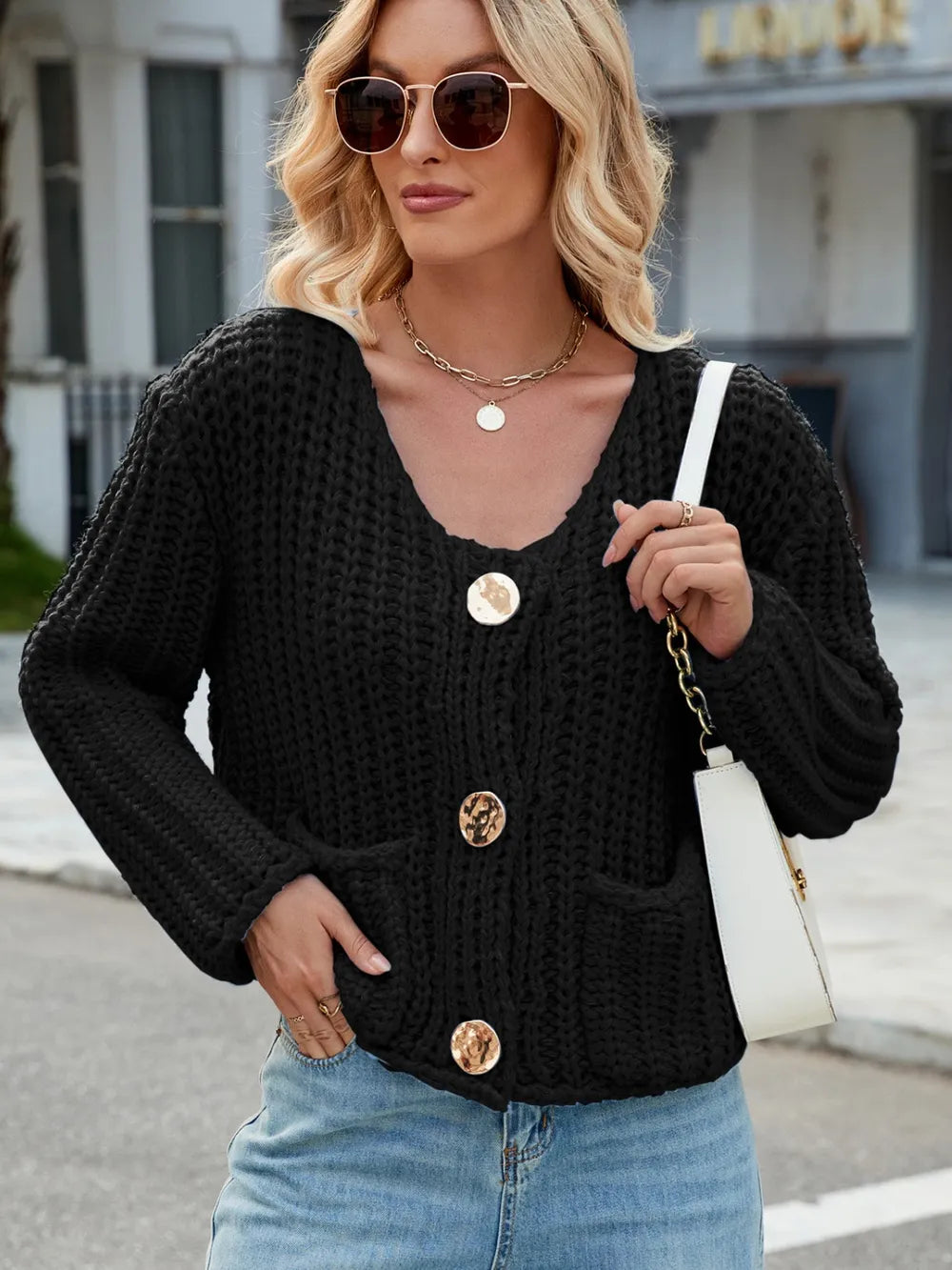 Black knit cardigan with long sleeves, round neckline, button front, patch pockets