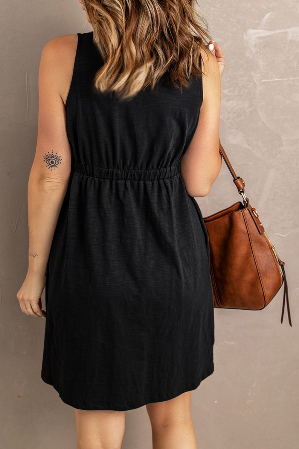 Sleeveless mini dress in dark black with gathered waist and button placket detail