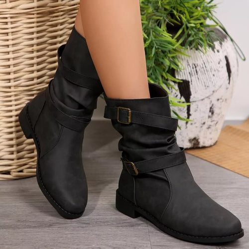 Black buckled low-heel ankle boots with wrap straps and gold-tone buckles