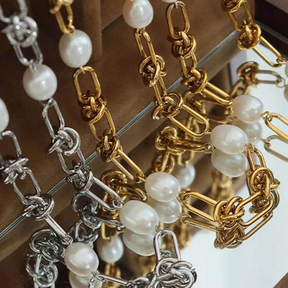 Close-up pearl chain bracelet with round white pearls on gold and silver links