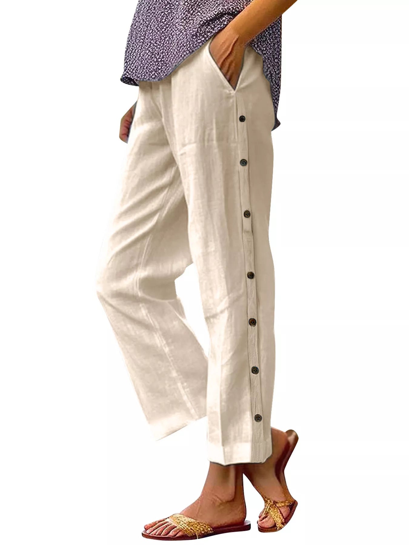 Light beige polyester pants with side buttons and side pockets; elastic waistband