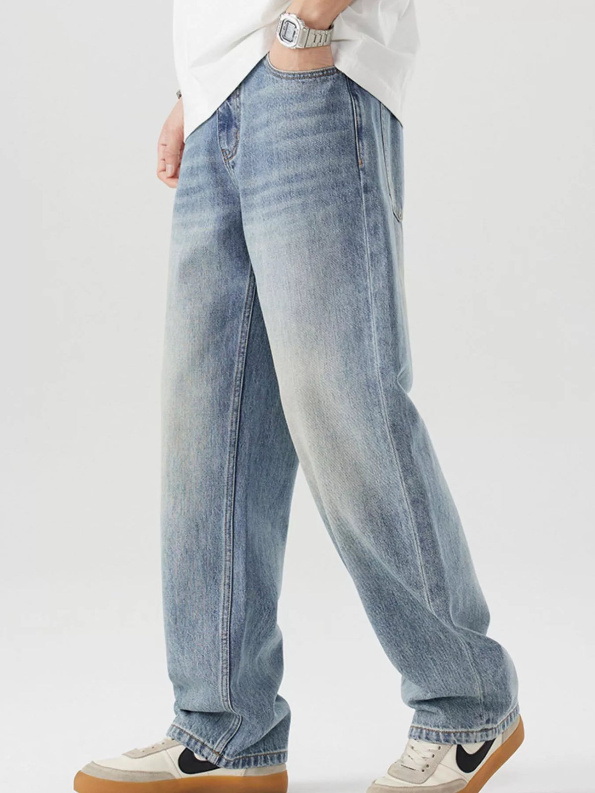 Blue vintage-wash cotton jeans, three-quarter view showing relaxed wide legs