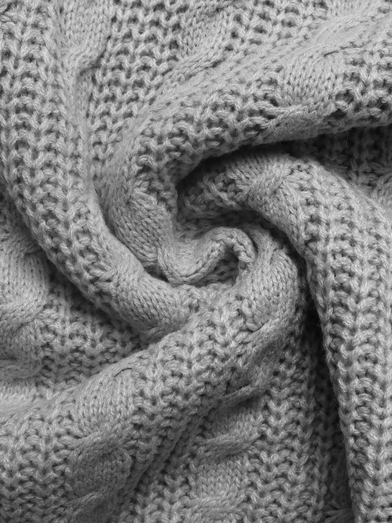 Gray cable knit sweater knit texture close-up on seam and stitch pattern