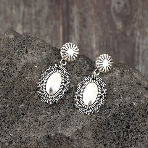 Silver flower dangle earrings with oval filigree medallion drops and round textured caps